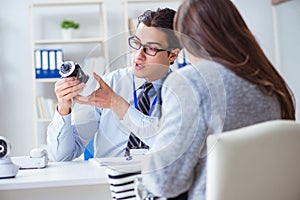 The sales assistant showing cameras to client in shop