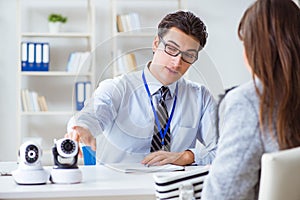 The sales assistant showing cameras to client in shop