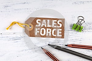Sales Force. Cardboard prices sign on a white wooden table