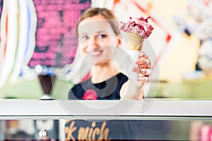 Sales girl handing wafer of ice cream over counter