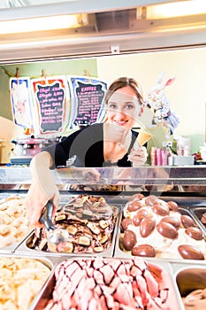 Sales girl portion s scoop of ice cream to wafer