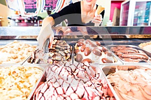 Sales girl portion s scoop of ice cream to wafer