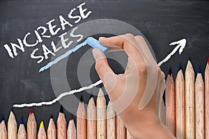 Sales increase concept or target on chalkboard with wave of colored pencils