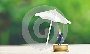 Sales insurance concept sales agreement business man holding briefcase bag and umbrella protecting business man on gold coin