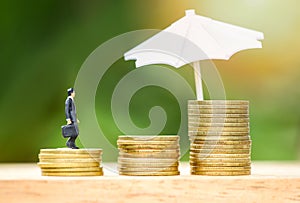 Sales insurance concept umbrella protecting gold coin step up growing