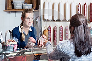 Sales lady in butchery shop serving customer