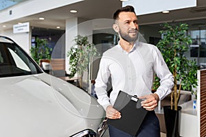 sales manager in a car dealership hands over the keys and documents to the car