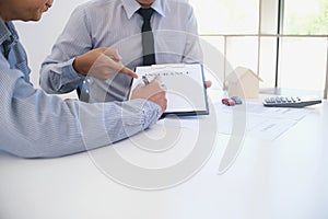 Sales manager giving advice application form document, considering mortgage loan offer for car and house insurance.