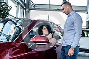 Sales manager giving keys from car to client