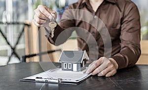 Sales manager or real estate agent prepares to hand over the keys and the house together with the insurance to the customer,Sales