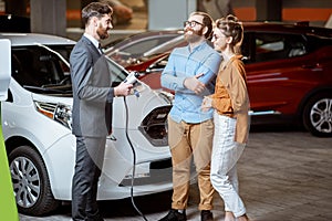 Sales manager selling electric car to a young couple