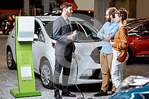 Sales manager selling electric car to a young couple