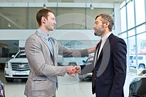 Sales Manager Shaking Hands with Client Buying Car