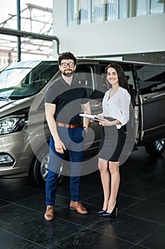 Sales manager showing to happy customer a car he won. Dealership, car rental