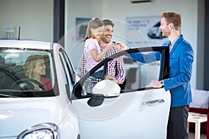 Sales manager at a showroom car with buyers