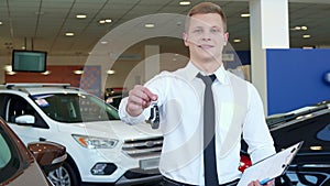 Sales manager shows car key at the dealership