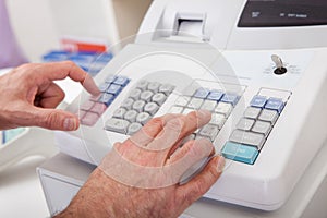 Sales person entering amount on cash register