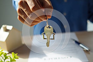 The sales representative is sending the keys to the customer after discussing the contract to buy the house, insurance or real
