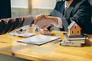 Sales representatives shake hands with customers and offer home purchase contracts to purchase current homes and leases offer home