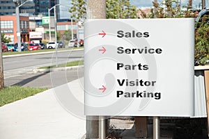 sales service parts visitor parking writing caption text silver black red sign. p138