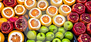 Sales stand for juice of apples, oranges and pomegranates with sliced fruits