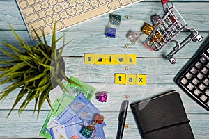 Sales Tax Conceptual - Flat Lay with Ringgit Malaysia, Shopping Cart, calculator, keyboard, notebook on blue wooden background