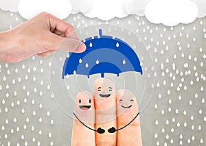 Salesman agent hand holding umbrella protection family.