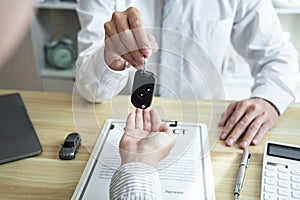 Salesman agent sending a key to customer after the good deal agreement, successful car loan insurance contract buying or selling