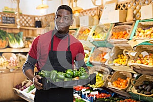 Salesman carrying box with green peppers