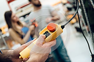 Salesman is checking contorl panel of device in power tools store.