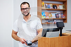 Salesman at the checkout in a bookstore