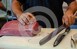 Salesman cut fillet of Red Tuna fish on farmers market