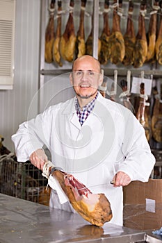 Salesman cutting jamon on slices