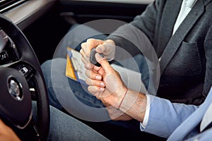 Salesman giving key of a new car to buyer, concept