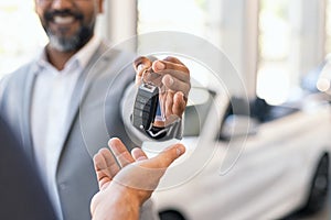Salesman giving new car keys to customer