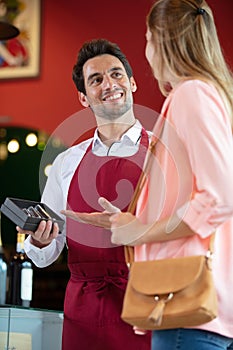 salesman giving woman advice on buying bottle red wine