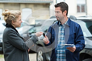 salesman handing over keys to new car photo