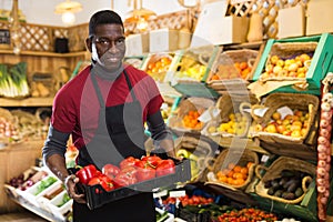 Salesman holding box with red peppers