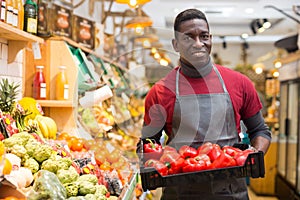 Salesman holding box with red peppers