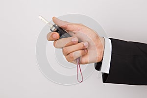 salesman holding car key, over gray background