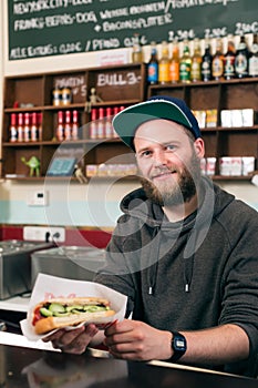 Salesman with hotdog in fast food snack bar