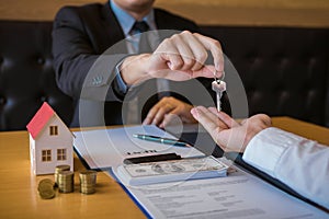 Salesman house brokers provide key to new homeowners in office photo