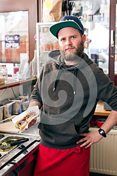 Salesman making hotdog in fast food snack bar