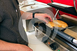 Salesman making hotdog in fast food snack bar