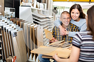 Salesman offering laminate flooring to couple