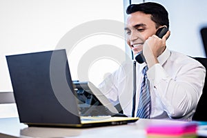 Salesman in office making phone call