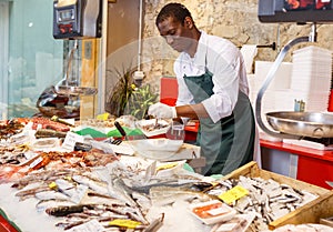 Salesman preparing fish for sale