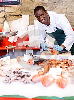 Salesman preparing fish for sale