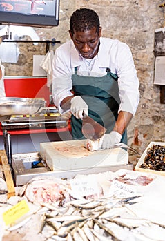 Salesman preparing fish for sale