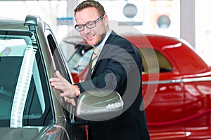 Salesman selling car at dealership